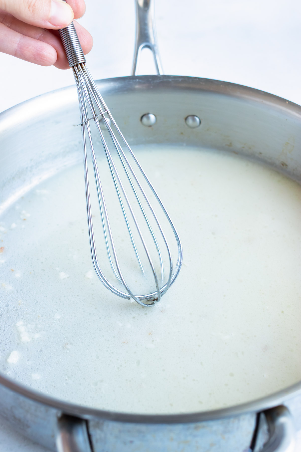 In a skillet, whisk together milk to make healthy carbonara sauce.