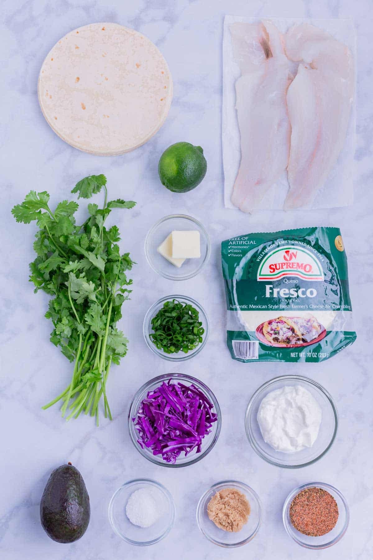 White fish, cilantro, blackened seasoning, avocado, sour cream, and cabbage are the main ingredients for these tacos.