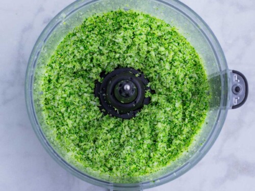 Steamed broccoli is chopped in a food processor.