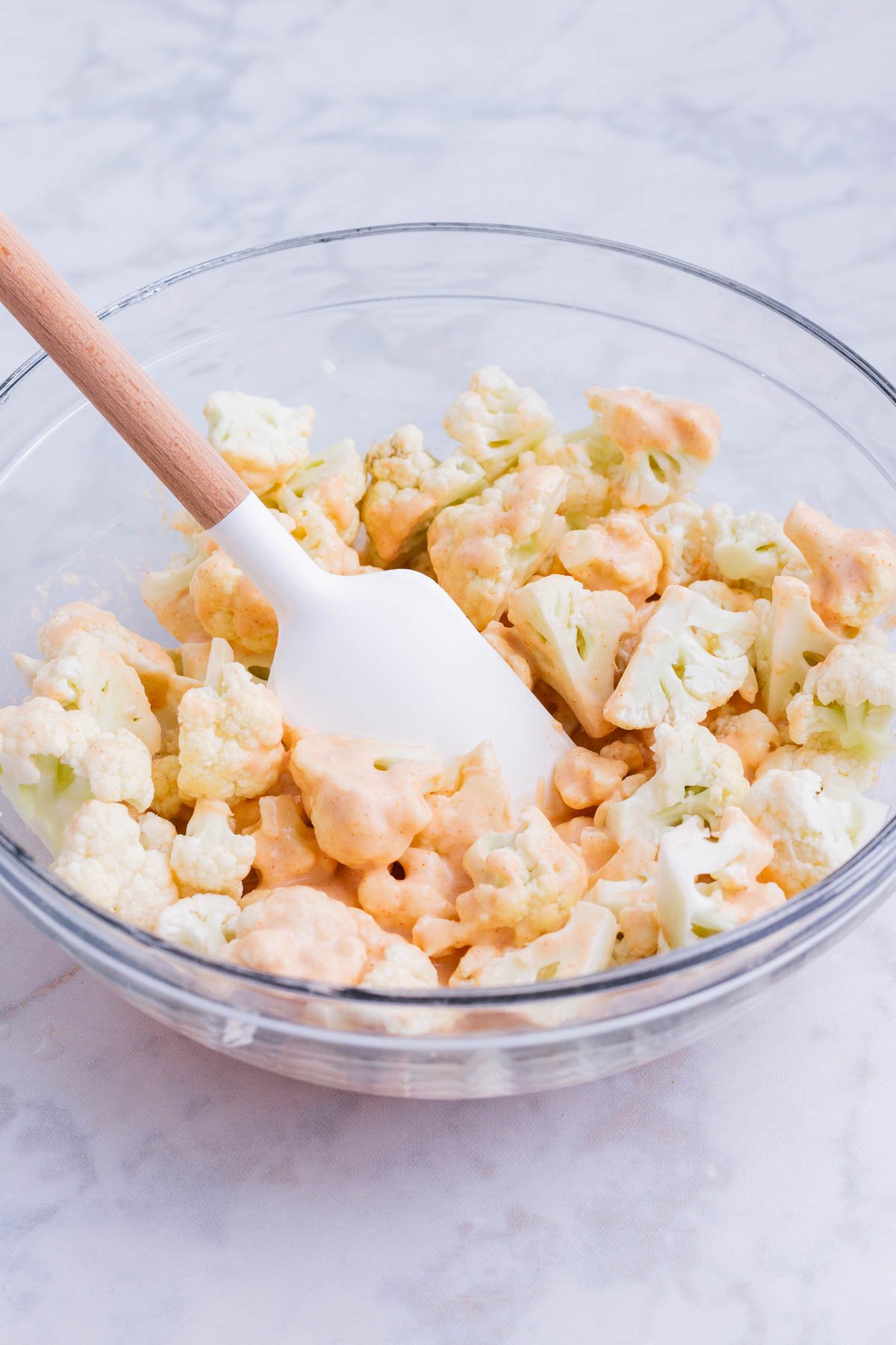 Cauliflower florets are tossed in the batter.