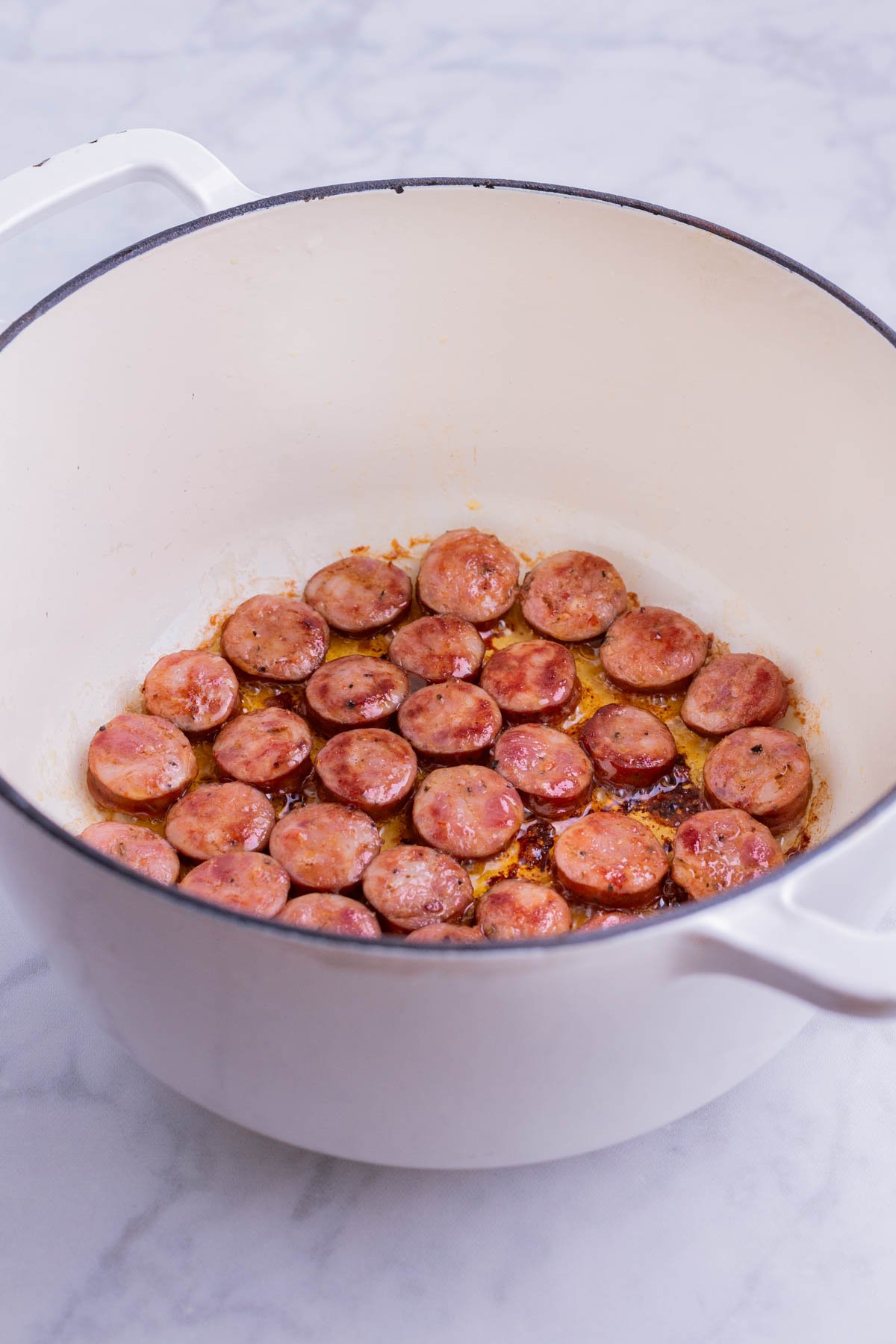 Sausage is cooked in a Dutch oven.