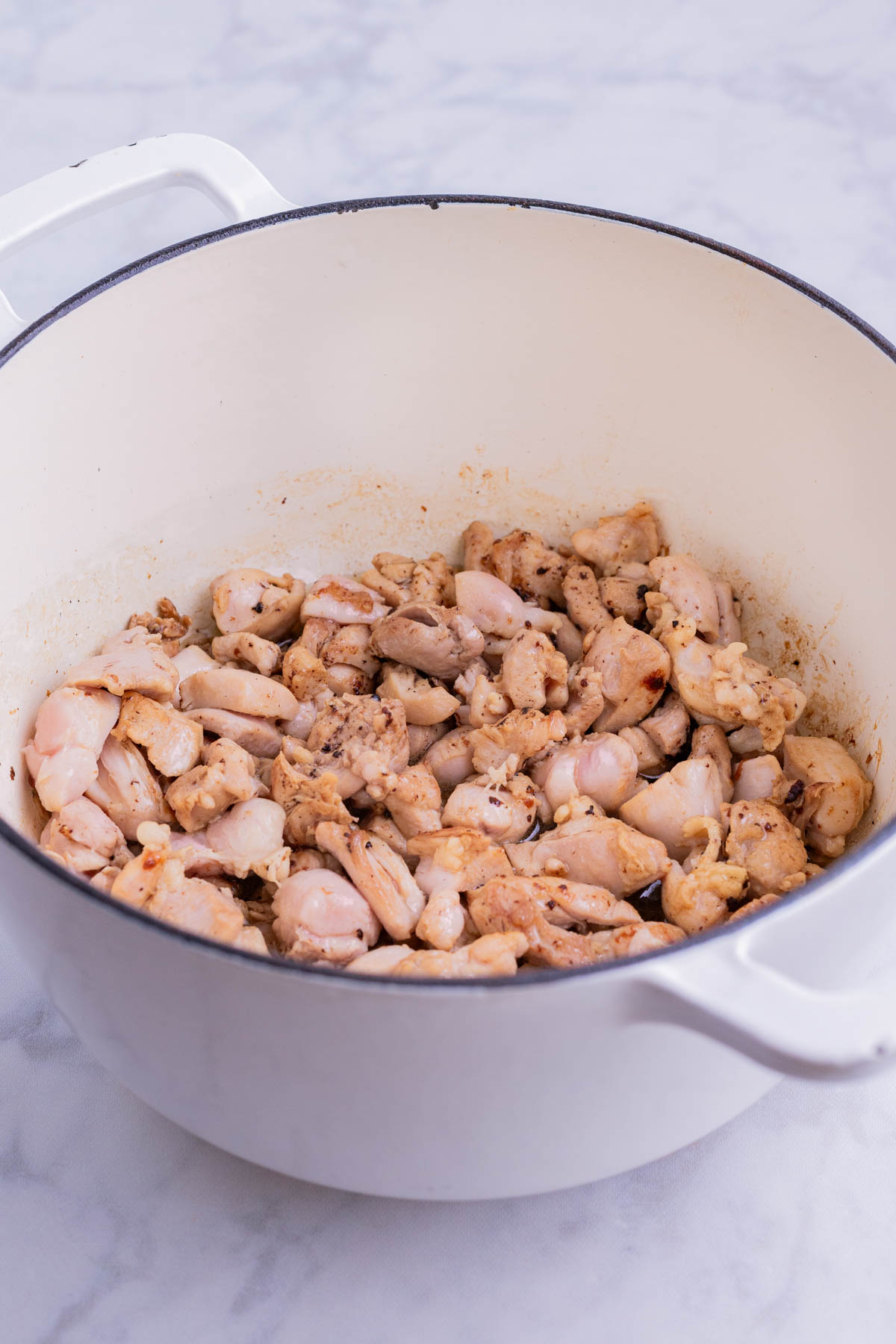 Chicken is cooked in a Dutch oven.