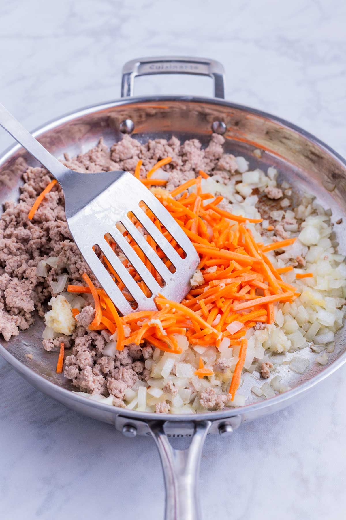 Carrots are stirred into the ground turkey mixture for an egg roll bowl recipe.