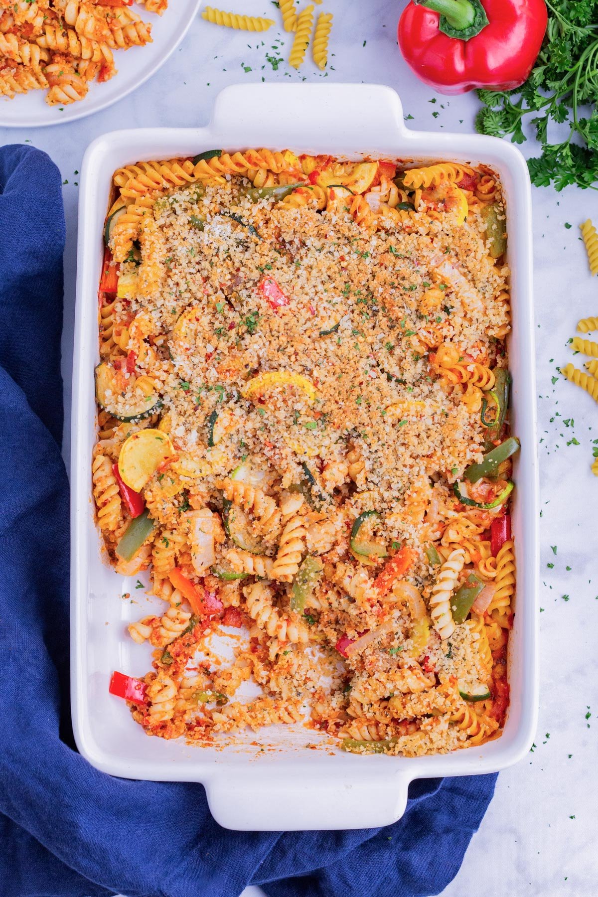 Pasta is mixed with roasted veggies, cheese, and sauce and baked in the oven.
