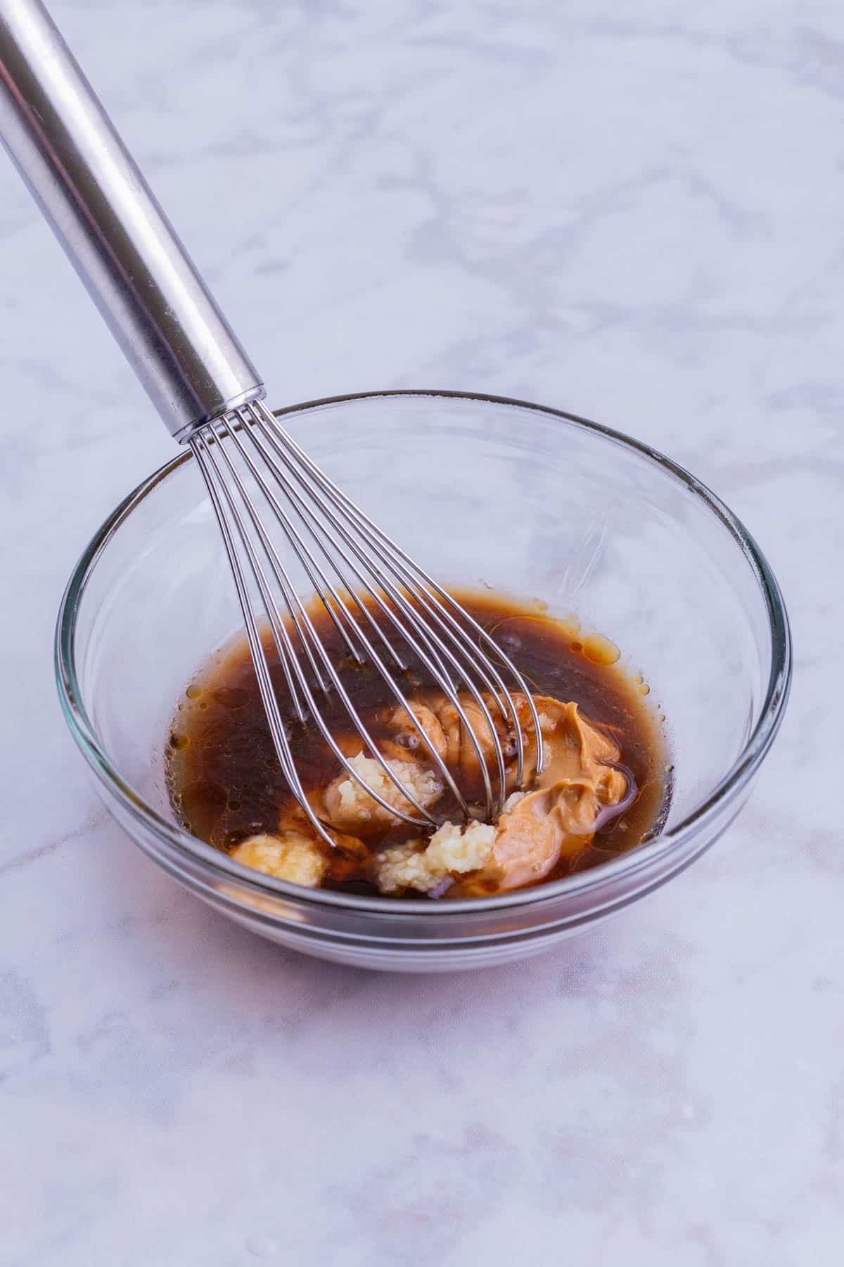 The dressing ingredients are whisked in a small bowl.