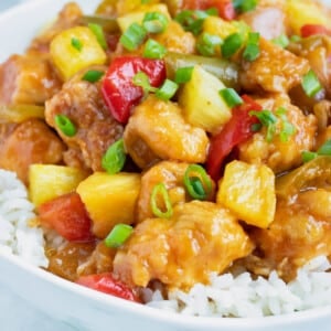 Pineapple Chicken is loaded with pineapple, bell peppers, and fresh green onions and laid over a rice.