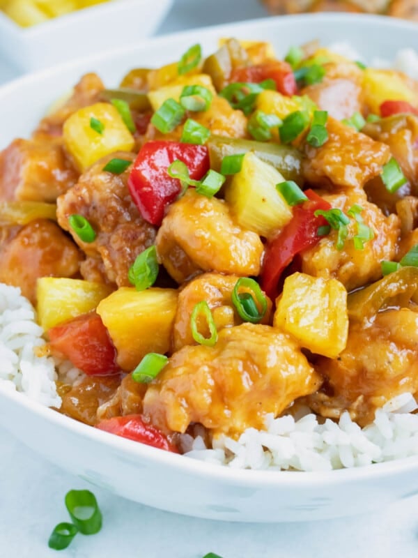 Pineapple Chicken is loaded with pineapple, bell peppers, and fresh green onions and laid over a rice.