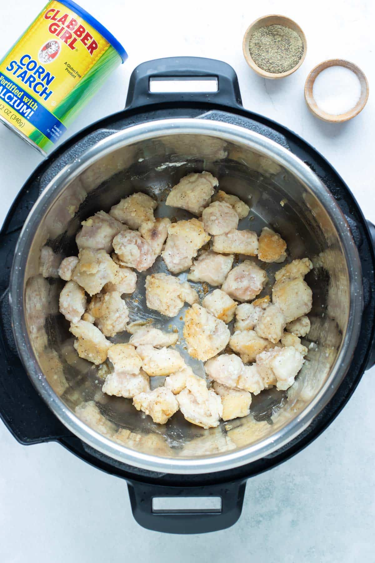 Cubed chicken is added to an instant pot.