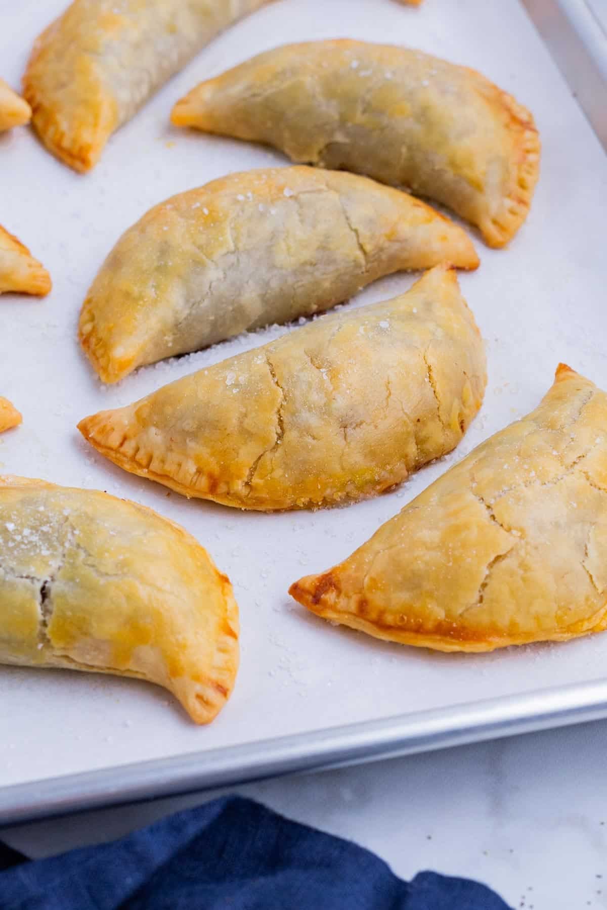 Golden baked beef empanadas fresh from the oven with flaky pie crust edges.