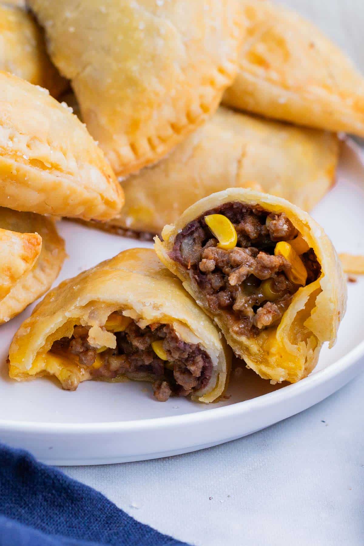 A beef empanada is cut in half to see the filling.