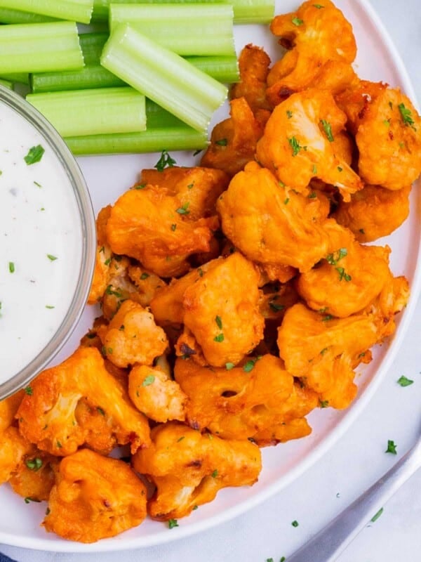 Cauliflower buffalo bites are served alongside celery sticks and ranch.