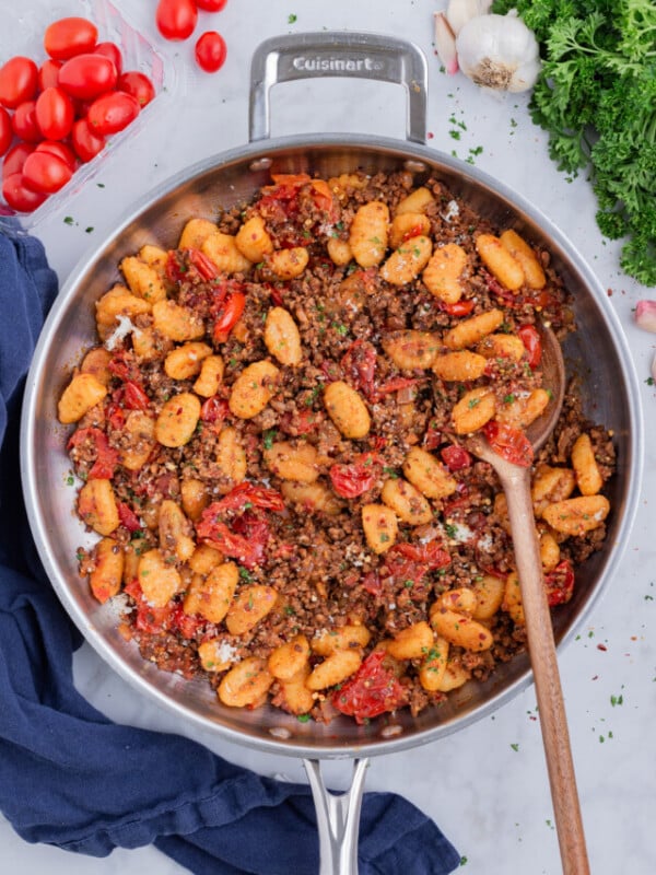 A skillet is full of a delicious gnocchi Bolognese dish.
