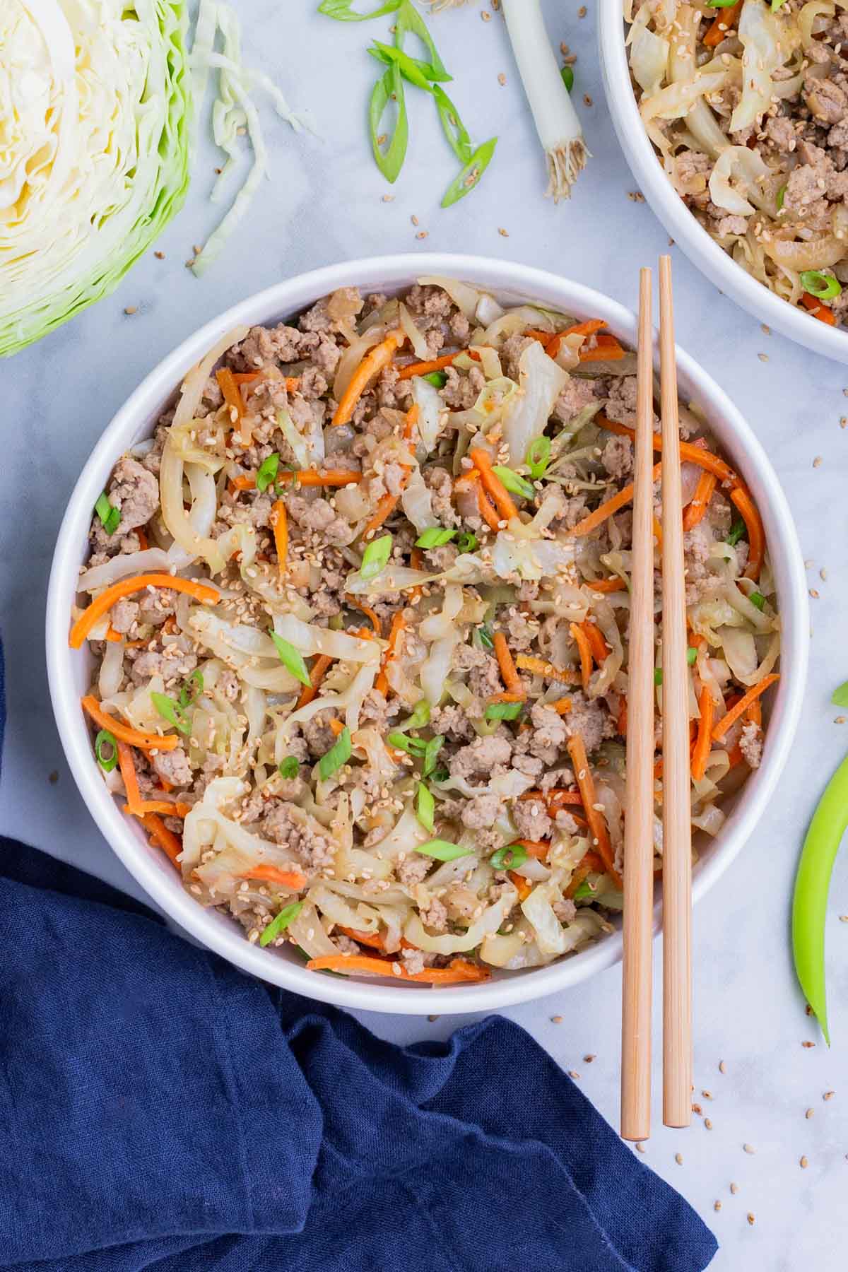 Keto and low-carb egg roll in a bowl dinner recipe with chopsticks and a blue napkin.