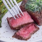 A medium rare steak is cut on a plate.