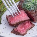 A medium rare steak is cut on a plate.