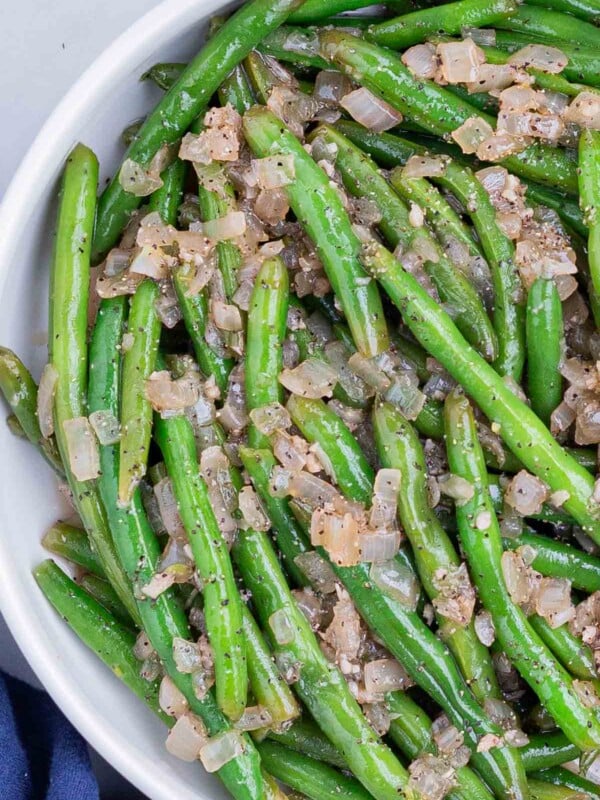 Green beans with vinegar are served in a white bowl.