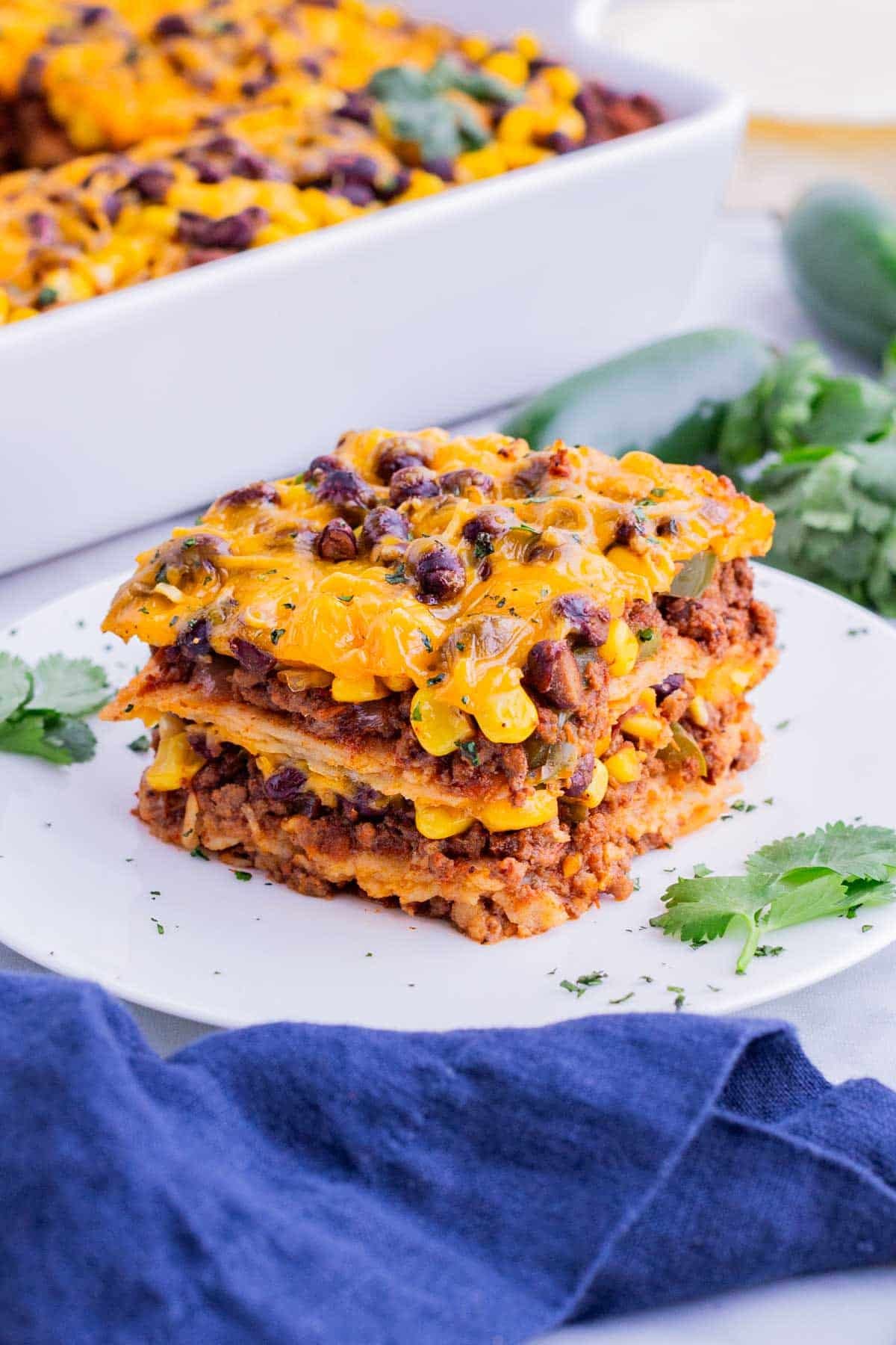 A single serving of Mexican lasagna is served on a white plate.