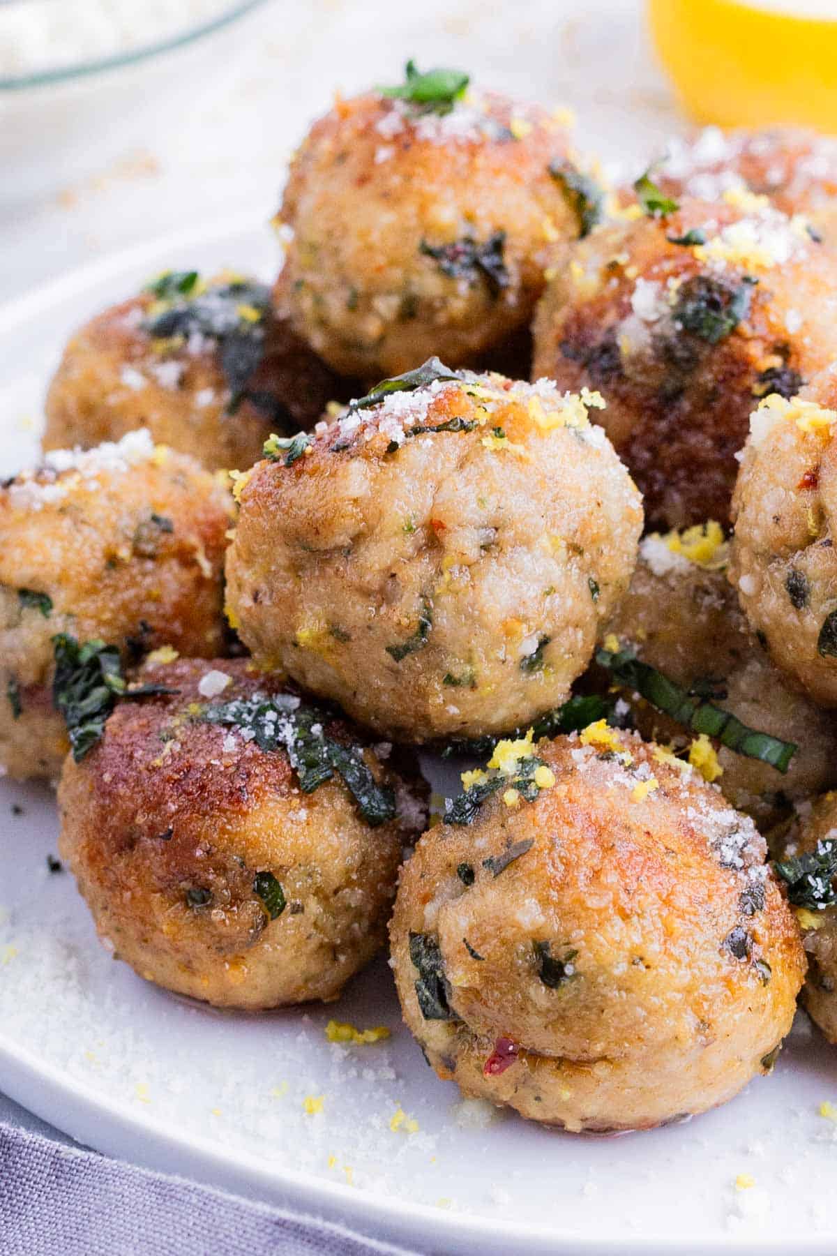Meatballs are made with ground chicken and Parmesan cheese and served as an appetizer.