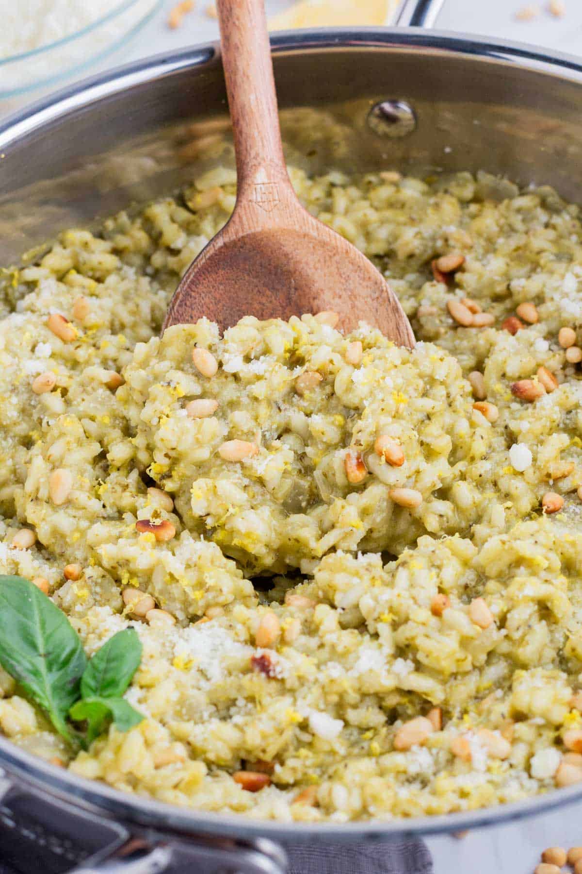 A wooden spoon stirs risotto on the stove top.