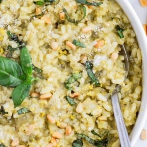 A spoon is used to serve pesto risotto.