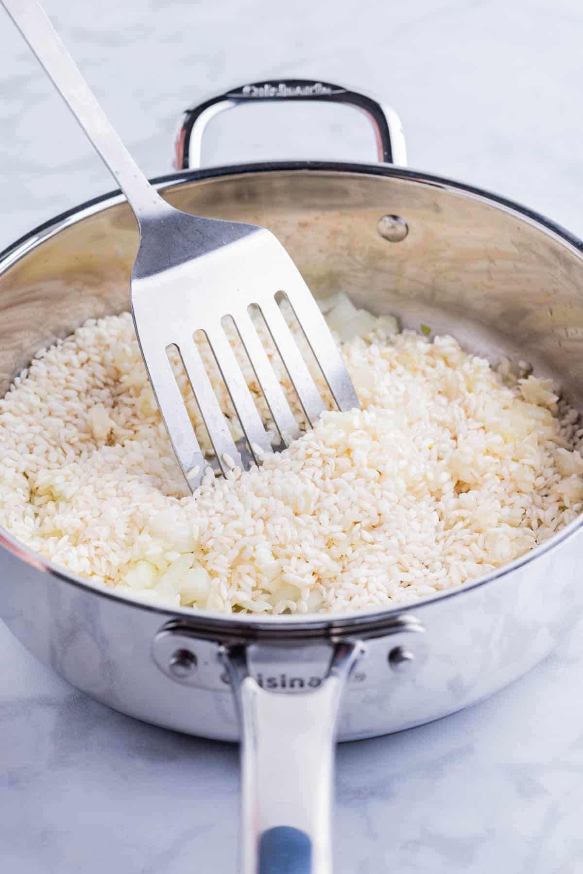 Arborio rice is added to the sauteed onion and garlic.