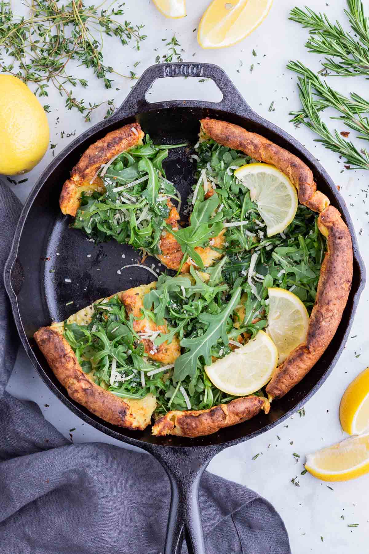 A savory Dutch baby is sliced before serving.