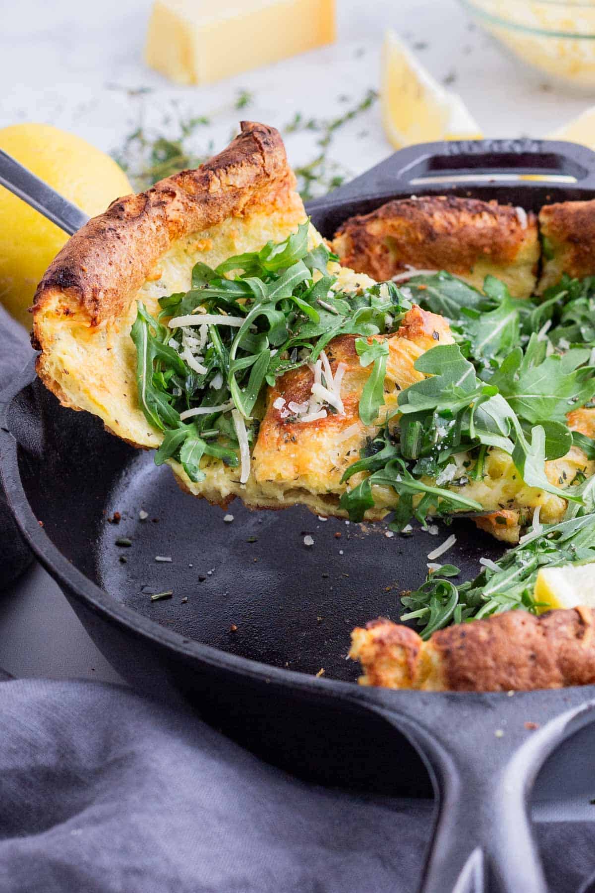A savory Dutch baby is sliced before serving.