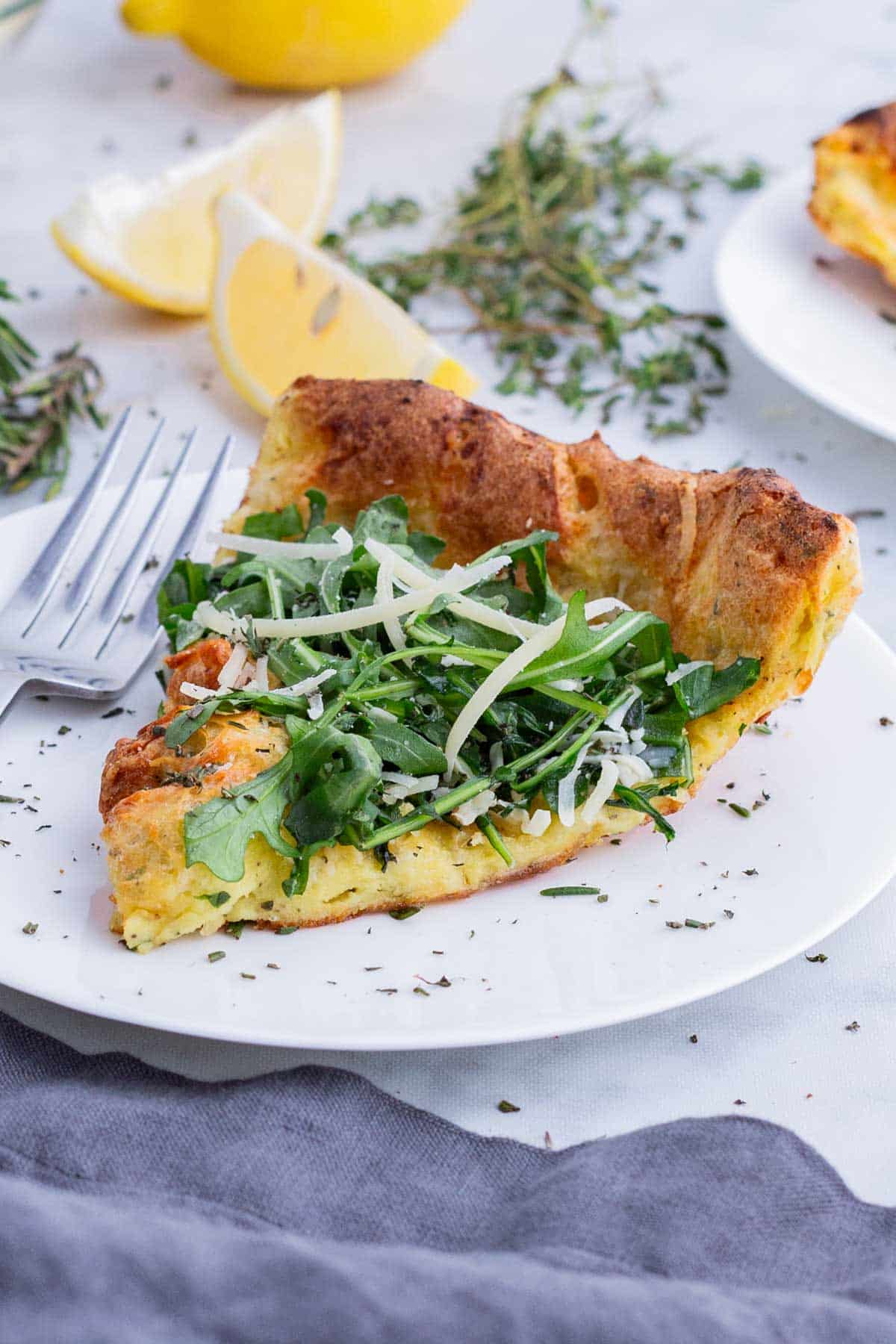 A slice of savory Dutch baby is served on a white plate.