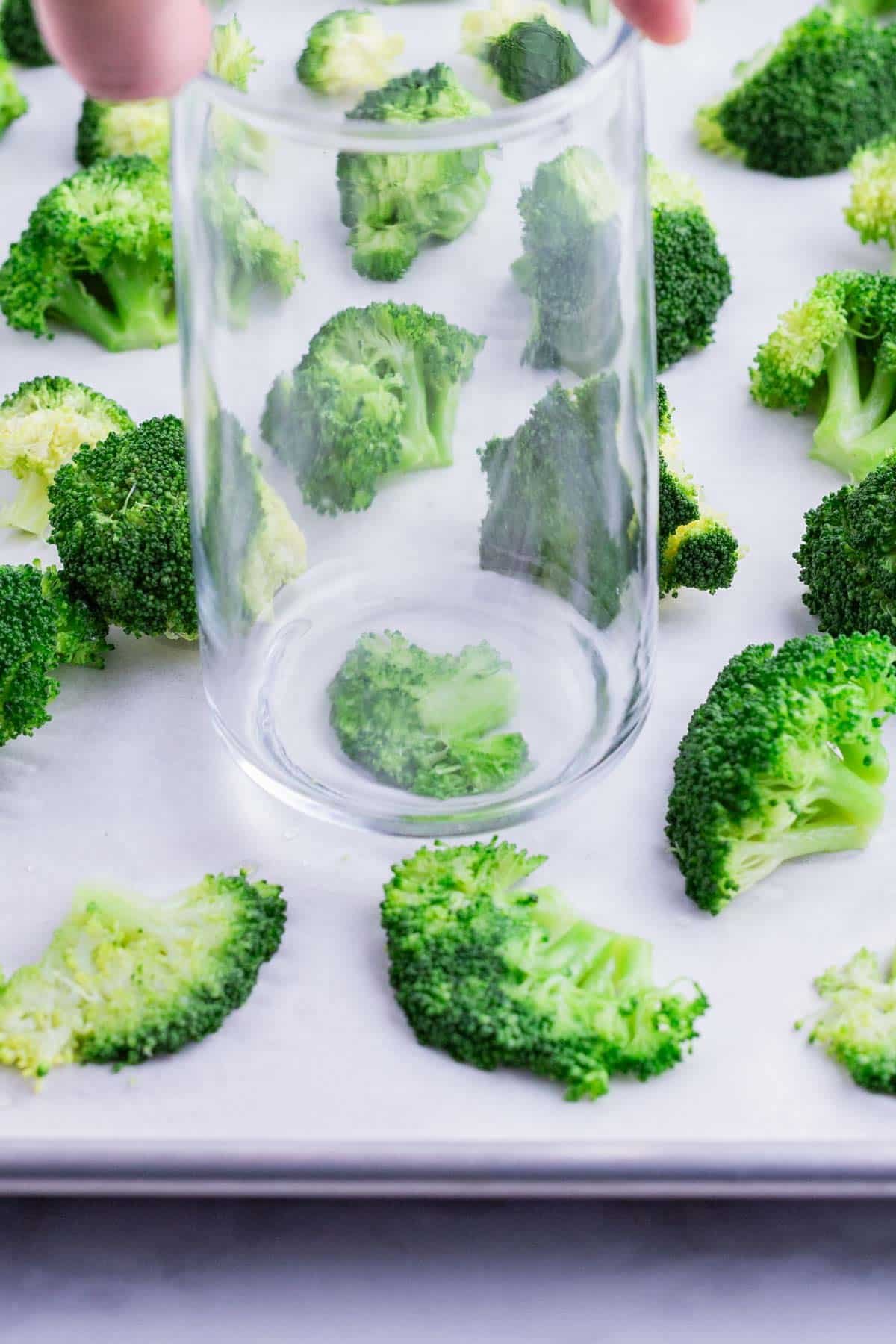 Boiled broccoli is smashed with the bottom of the glass.