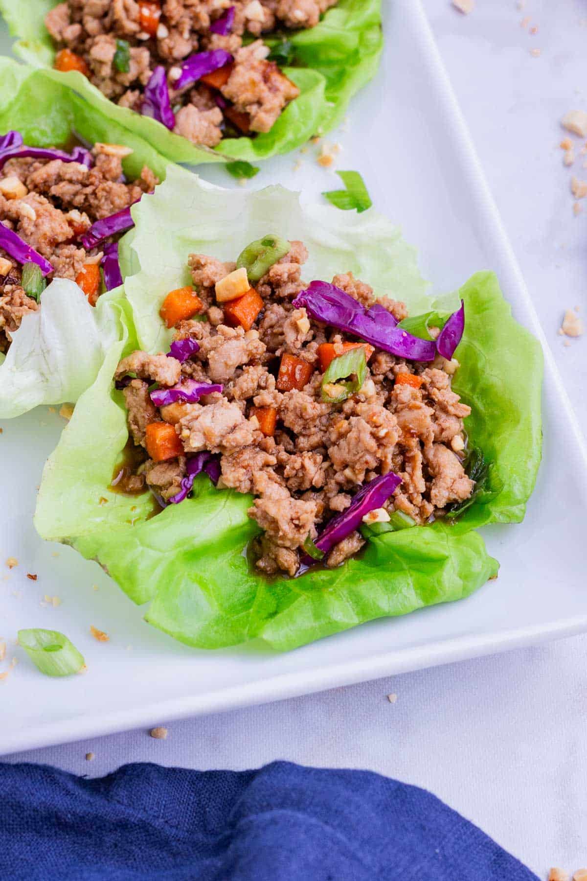 Thai-flavored chicken is served inside a lettuce leaf for a low carb meal.