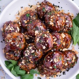 Thai meatballs are served in a white plate with quinoa salad.