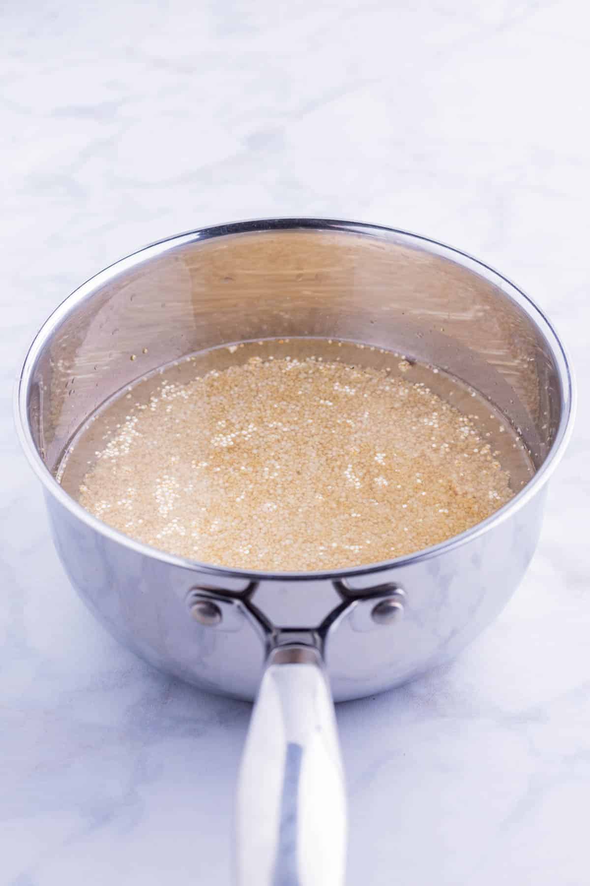 Quinoa is cooked in a saucepan.