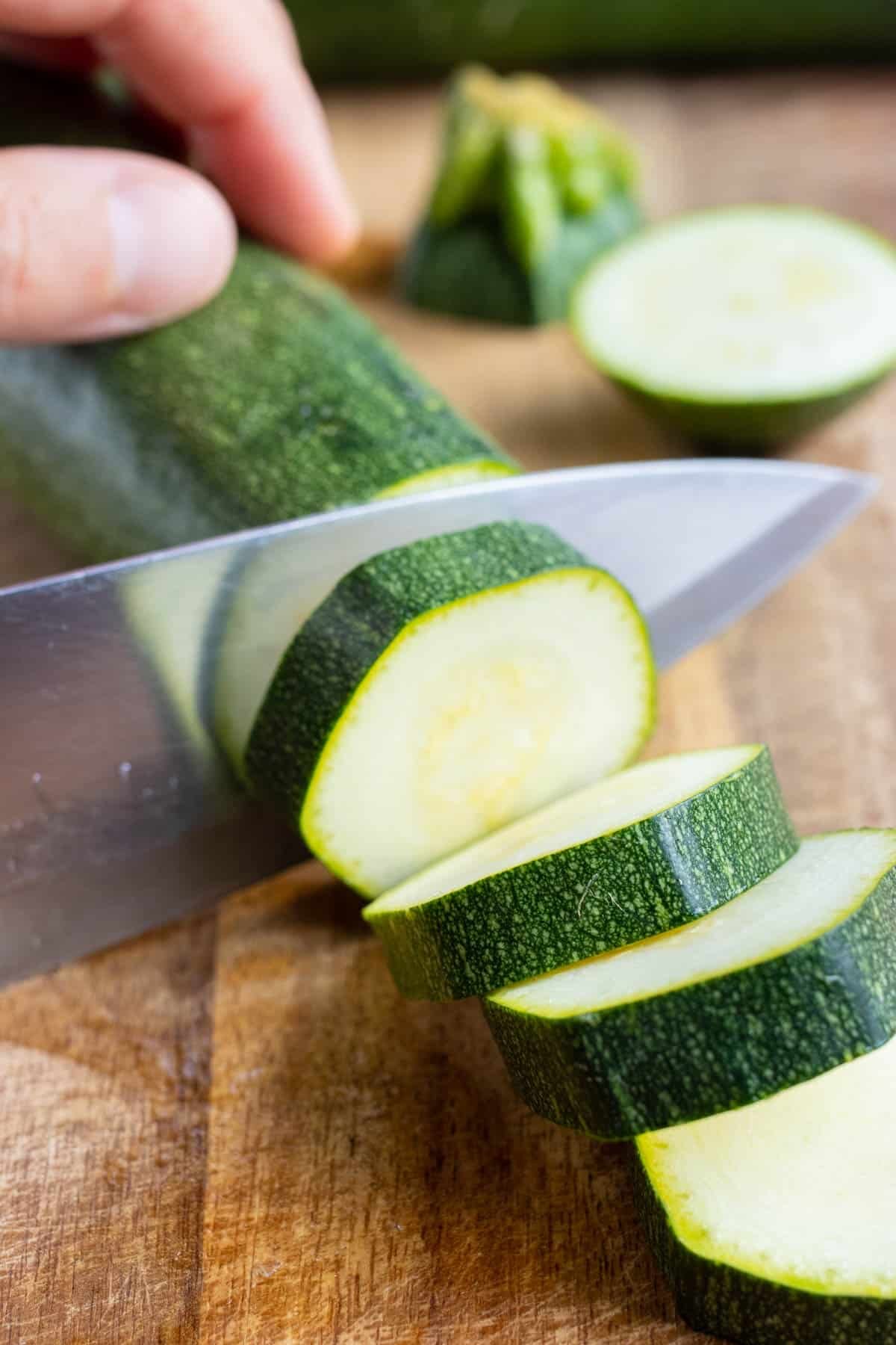 Zucchini is cut into slices before blanching and freezing.