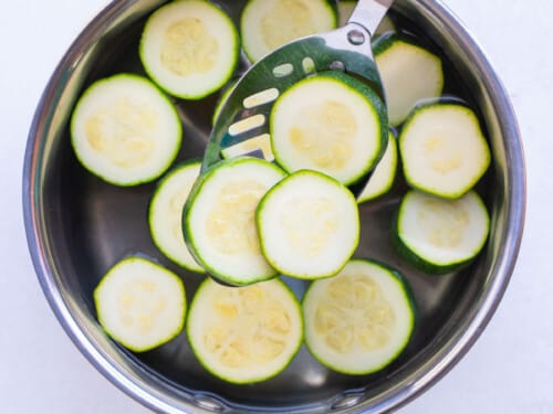 Zucchini is quickly cooked in boiling water before blanching and freezing.
