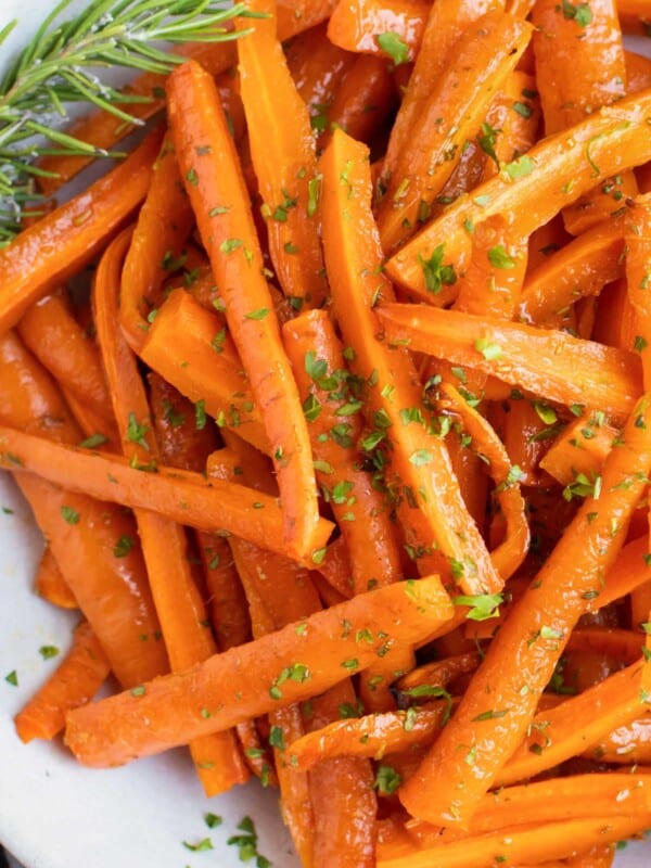Overhead picture of honey roasted carrots in a white bowl with rosemary.