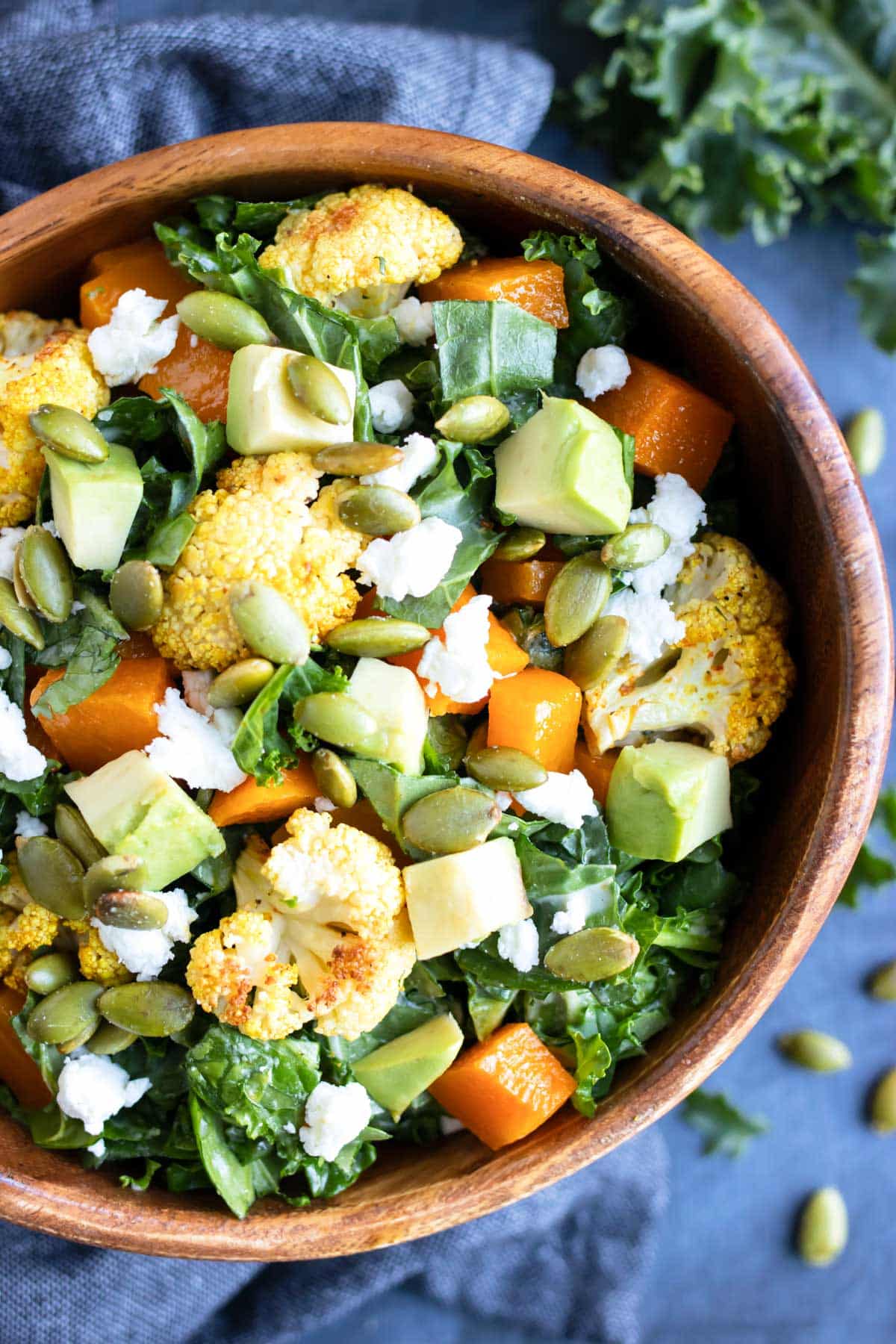 Roasted Cauliflower Kale Salad with Tahini Dressing RECIPE served in a wooden bowl.