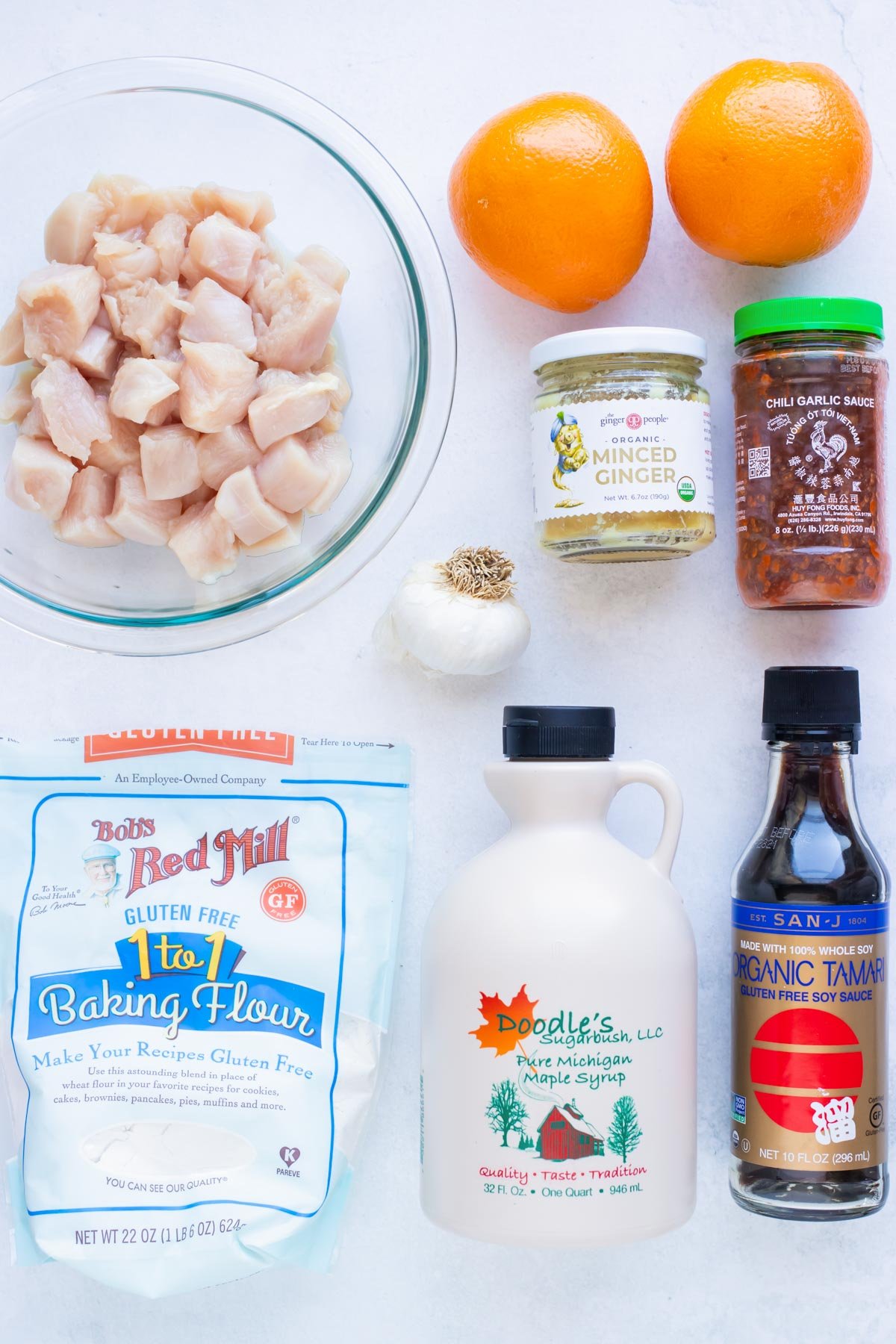 Chicken breasts, oranges, Tamari sauce, and flour as the ingredients needed for a gluten free orange chicken recipe.