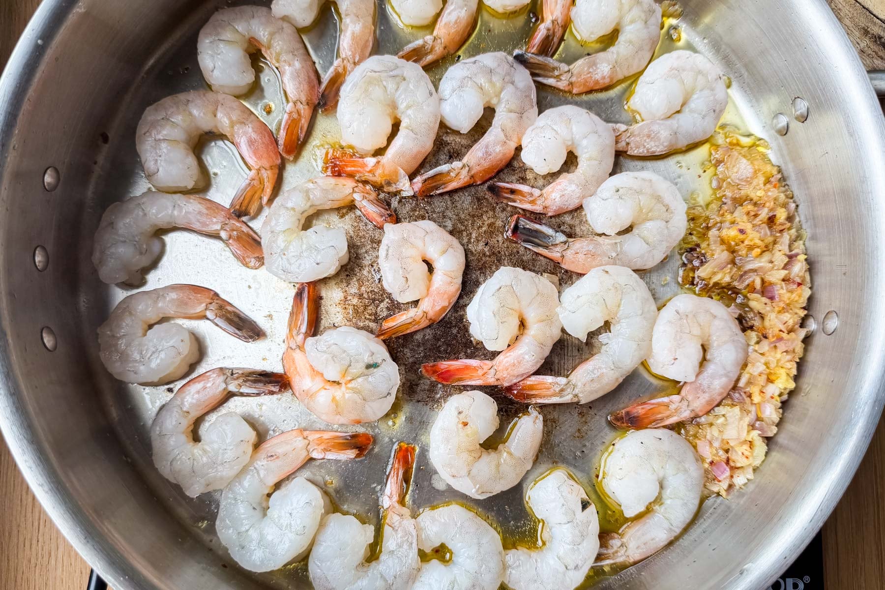 Raw shrimp searing in a single layer for easy shrimp scampi linguine