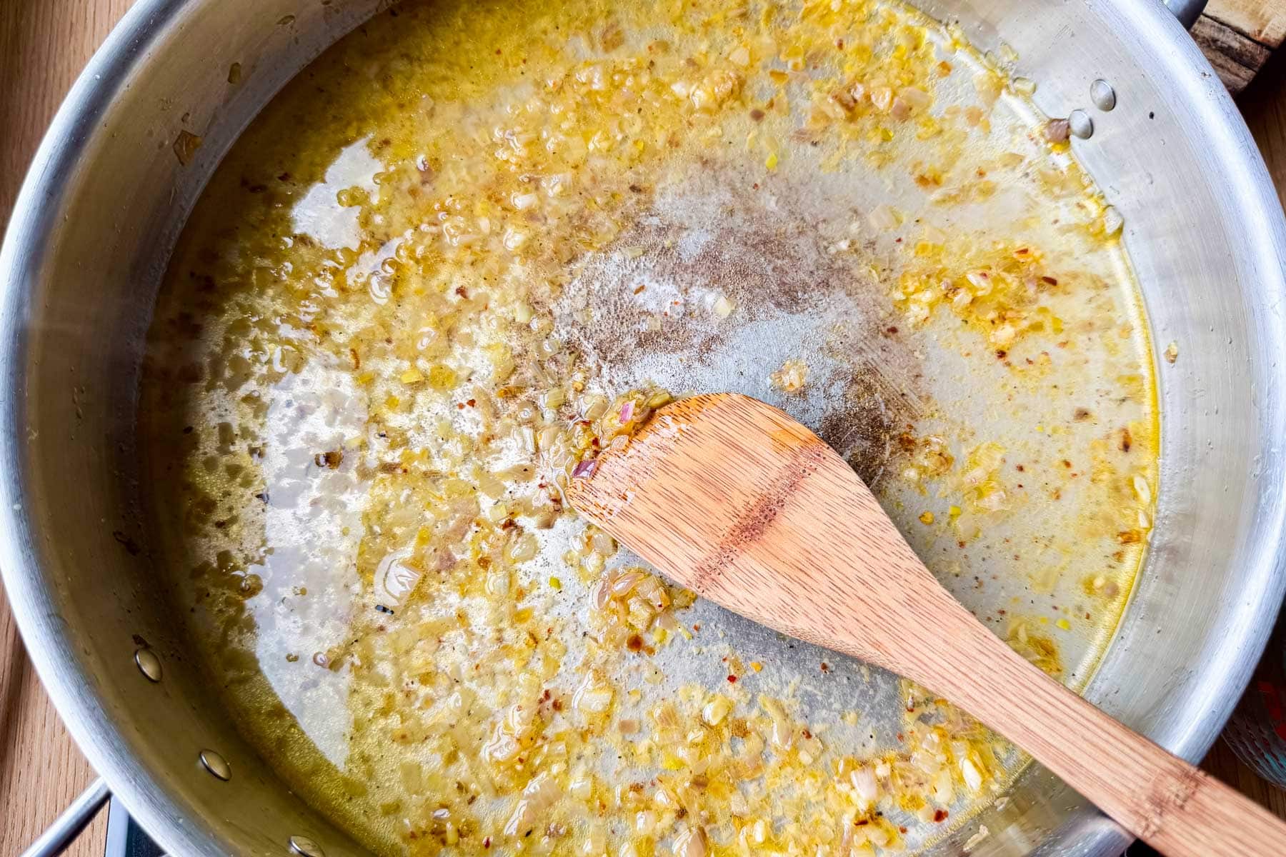 Garlic butter and white wine sauce simmering in a skillet for shrimp scampi with pasta