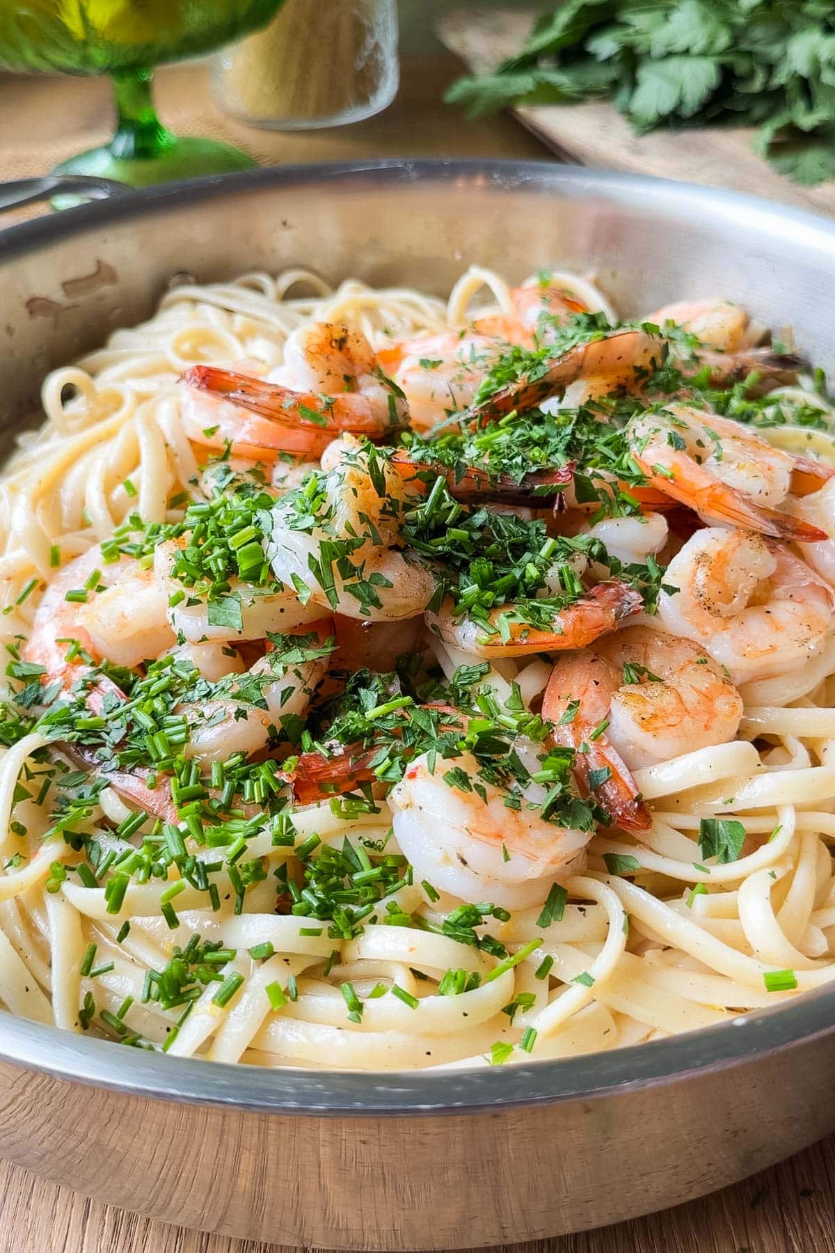 Finished shrimp scampi linguine tossed with fresh parsley and chives in a skillet
