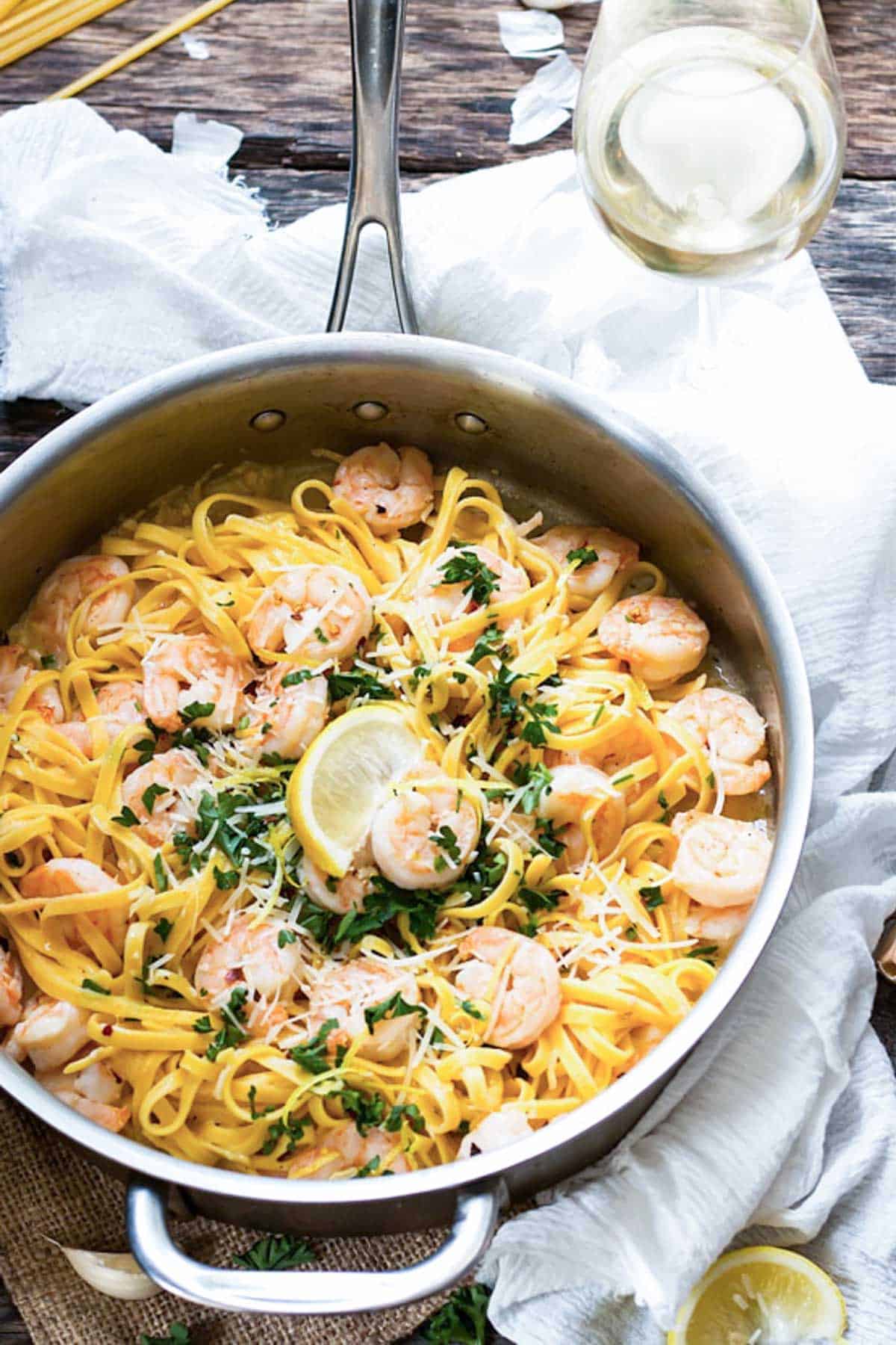A pan of healthy shrimp scampi with a slice of lemon in the middle ready to eat for dinner.
