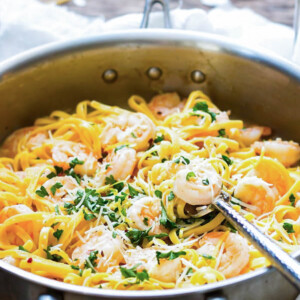 A pan filled with an easy shrimp scampi recipe with a fork in the middle for a healthy dinner.