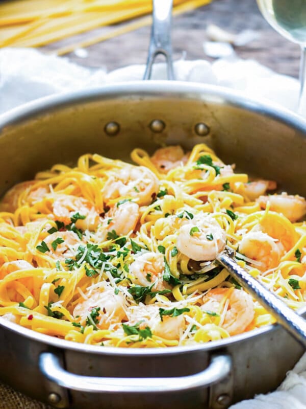 A pan filled with an easy shrimp scampi recipe with a fork in the middle for a healthy dinner.
