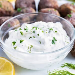 A bowl full of homemade Greek tzatziki sauce with cucumber and dill is served with Mediterranean Lamb meatballs.