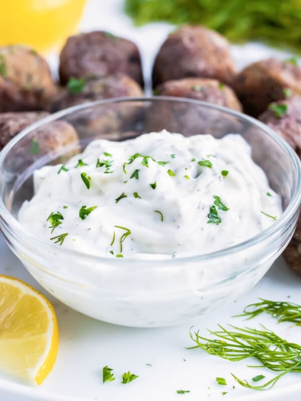 A bowl full of homemade Greek tzatziki sauce with cucumber and dill is served with Mediterranean Lamb meatballs.