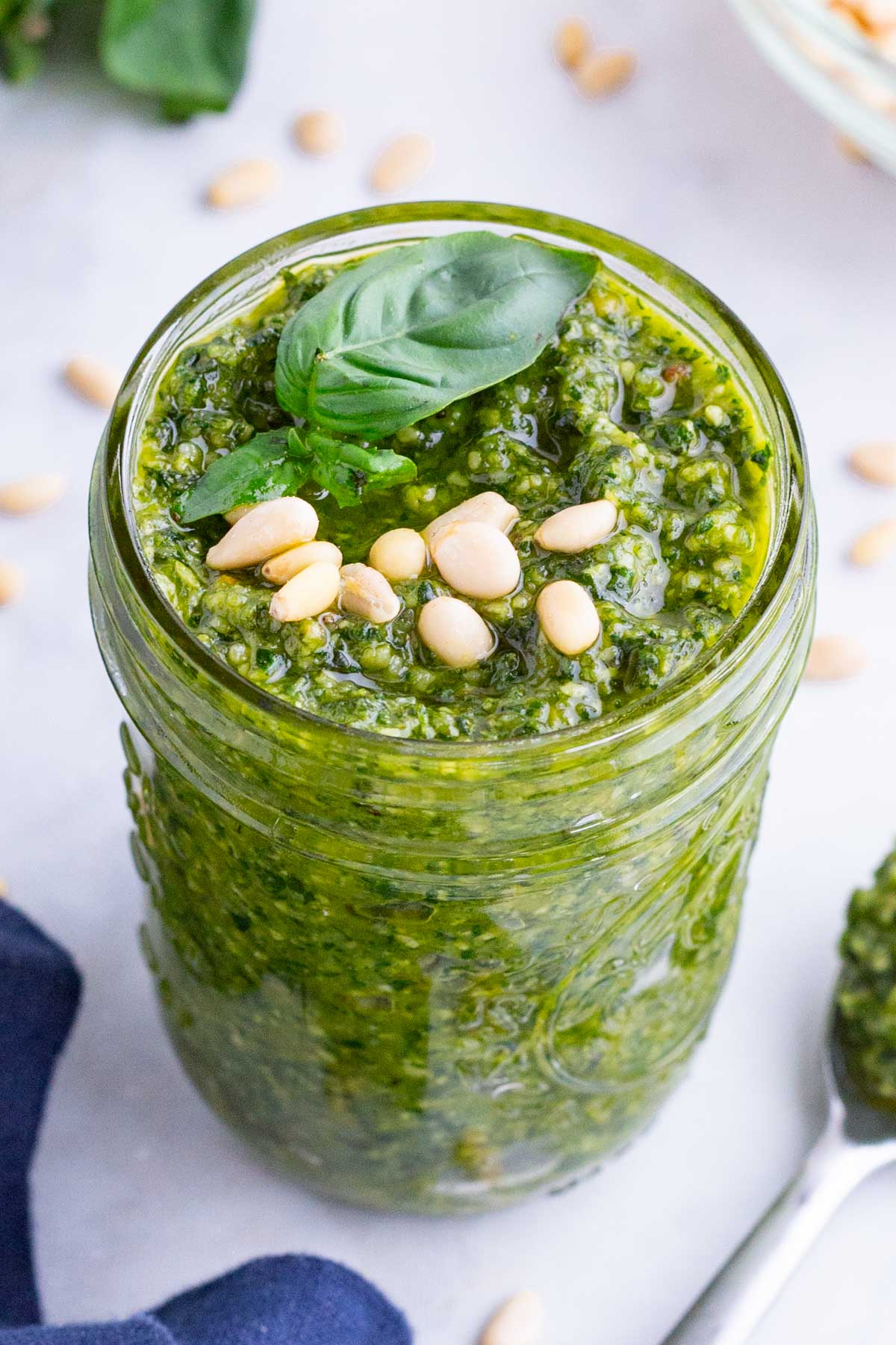 Basil leaves top a fresh basil pesto sauce to be used with bruschetta, pasta, or chicken recipes.