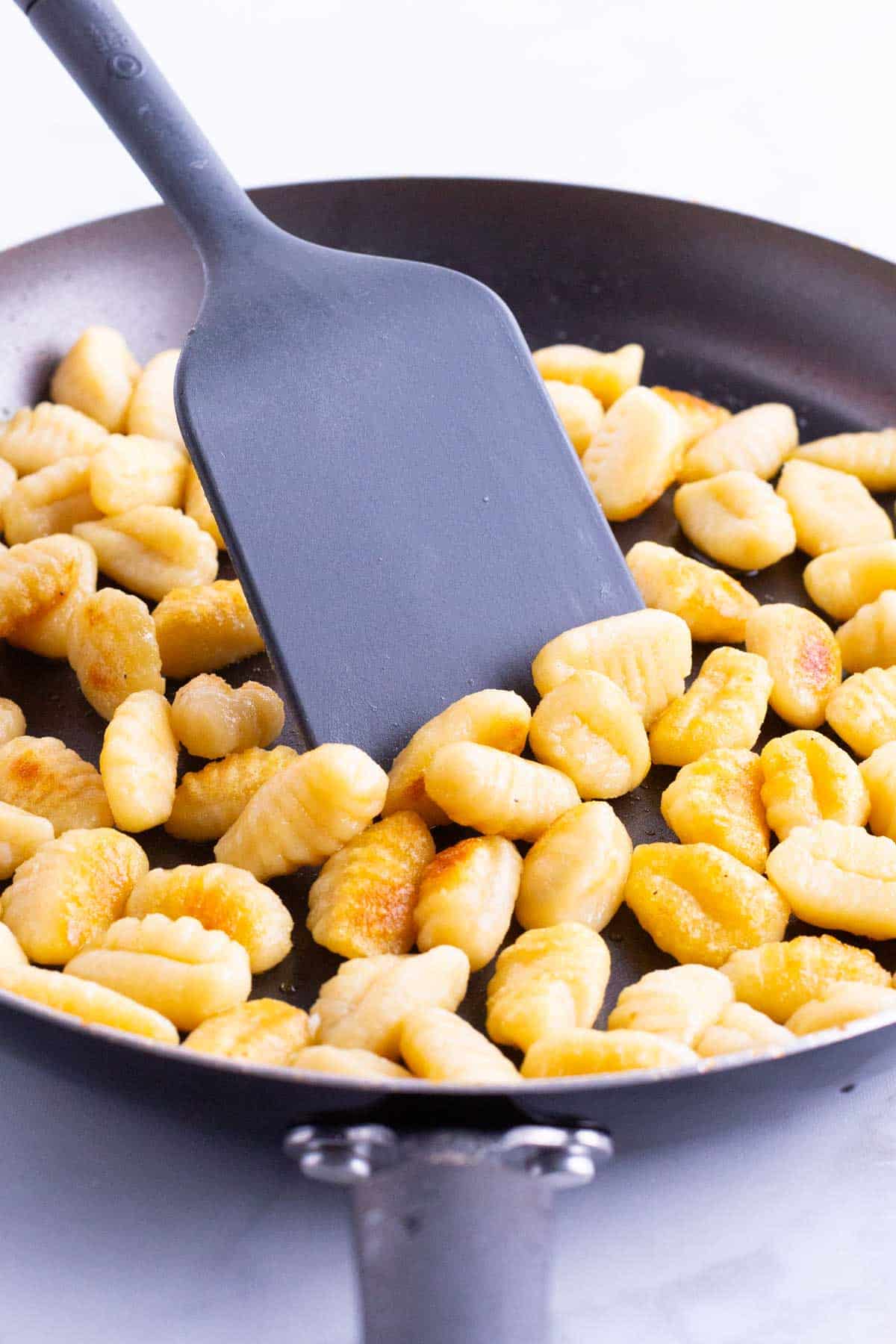 Gnocchi is cooked in a skillet.