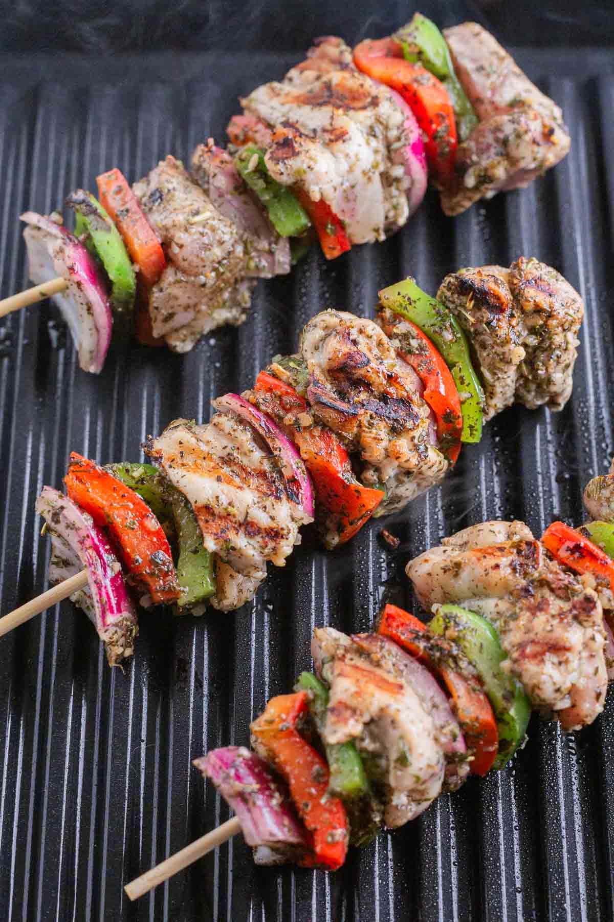 Marinated chicken and vegetable kabobs are grilled.