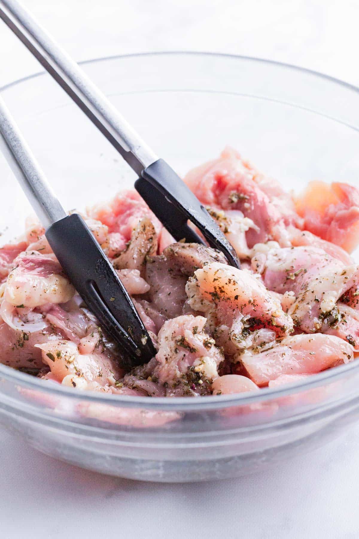 Sliced chicken is marinated before grilling.
