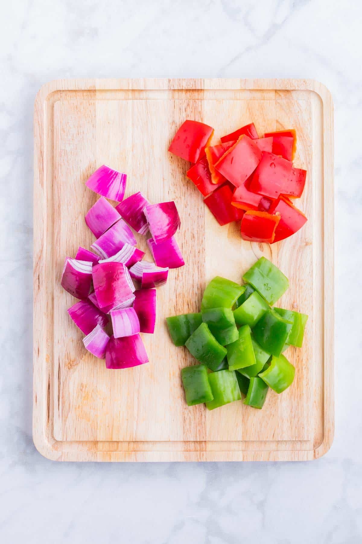 Onion and bell peppers are sliced before grilling.